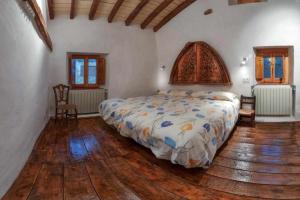 a bedroom with a bed and a wooden floor at Casa Rural La Chascona in Pedrajas