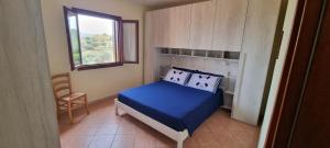 a small bedroom with a blue bed and a window at casa di Chiara in San Teodoro