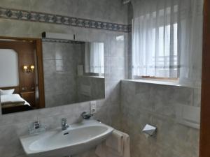 W łazience znajduje się umywalka i lustro. w obiekcie Gasthof Pension Traube w mieście Karres