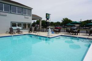 une grande piscine bleue en face d'un hôtel dans l'établissement Quality Inn & Suites Georgetown - Seaford, à Georgetown