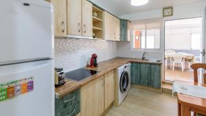 a kitchen with wooden cabinets and a white refrigerator at Villa Isabel Malaga - Churriana by Ruralidays in Málaga