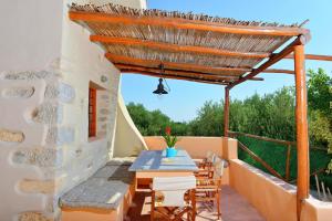 a patio with a table and chairs under a roof at Elounda Collection Villa in Vrouchas