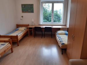 a room with two beds and a desk and a window at Salwator Apartments in Krakow