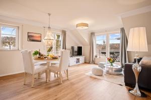 a dining room and living room with a table and chairs at Ferien-Apartment Irisblüte - mit priv Strandzugang in Friedrichshafen