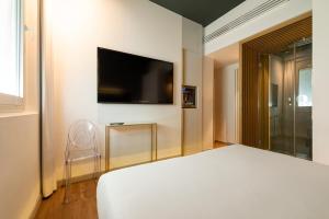 sypialnia z łóżkiem i telewizorem z płaskim ekranem w obiekcie Maison Pellegrino w Rzymie