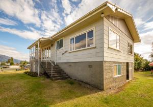 Una casa con escaleras que conducen a ella. en Grand View - Te Anau Holiday Home, en Te Anau