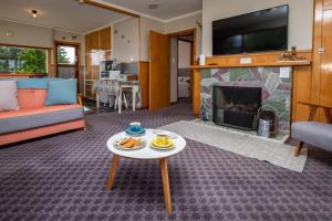 Una sala de estar con una mesa y una chimenea. en Grand View - Te Anau Holiday Home, en Te Anau 15 fotos más