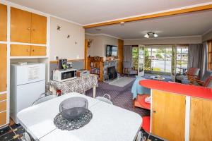 a kitchen and a living room with a table and a counter at Grand View - Te Anau Holiday Home in Te Anau