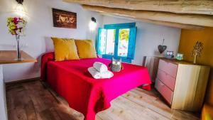 a bedroom with a red table with a cat on it at Casa La Higuera Competa by Ruralidays in Frigiliana +18 photos