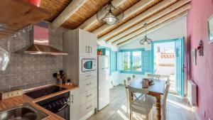a kitchen with a sink and a table with chairs at Casa La Higuera Competa by Ruralidays in Frigiliana