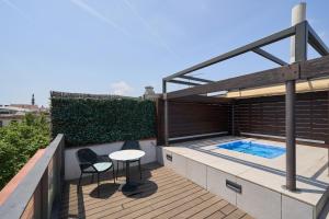 a rooftop deck with a table and chairs and a swimming pool at Catalonia Port in Barcelona