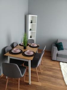 stół jadalny z 4 krzesłami i kanapą w obiekcie Apartament Miłosz w mieście Ełk