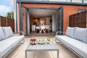 un patio con 2 sofás y una mesa en Elliot Oliver - The Old Surgery - Stunning 4 Bedroom Home With Parking In Cheltenham, en Cheltenham