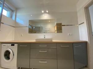 łazienka z umywalką i pralką w obiekcie Apartament Miłosz w mieście Ełk