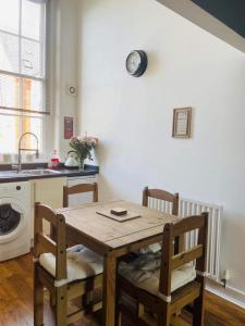 uma mesa e cadeiras numa cozinha com um lavatório em 2 Bed Self Contained Apartment Wrexham em Wrexham