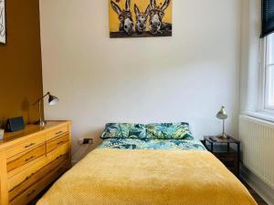 um quarto com uma cama, uma cómoda e um quadro em 2 Bed Self Contained Apartment Wrexham em Wrexham