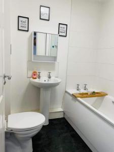 a bathroom with a toilet and a sink and a tub at 2 Bed Self Contained Apartment Wrexham in Wrexham