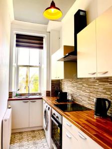 a kitchen with a sink and a stove top oven at Anchored Homely Apartment in Historic Centre in Paisley