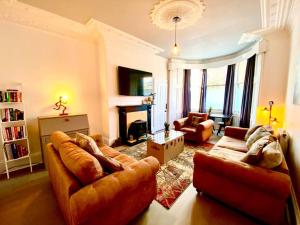 a living room with two couches and a fireplace at Anchored Homely Apartment in Historic Centre in Paisley