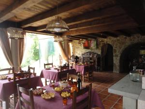 a restaurant with purple tables and chairs in a room at Caseria la Infiesta in Caleao