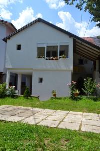 Una casa blanca con una ventana con flores. en Rzav, en Višegrad