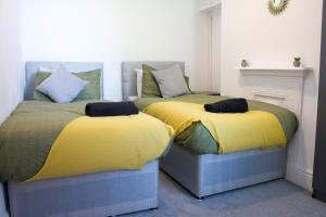 two beds sitting next to each other in a room at Boaler House, modern 4 Bed House with parking Sleeps 8 in Liverpool