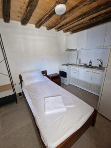 ein Schlafzimmer mit einem Bett und eine Küche mit weißen Schränken in der Unterkunft Panorama of seladi in Kástron