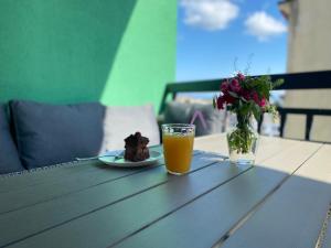 una mesa con un plato de pastel y un vaso de zumo de naranja en Home № 1, en Kutaisi