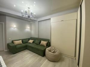 sala de estar con sofá verde y silla en Home № 1, en Kutaisi