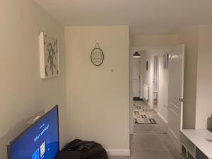 Alpha, Private Double Room, City Centre, Free Parking, Sittingbourne, Kent في سيتينغبورن: غرفة معيشة مع تلفزيون وساعة على الحائط