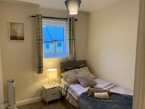 Alpha, Private Double Room, City Centre, Free Parking, Sittingbourne, Kent في سيتينغبورن: غرفة نوم بها سرير ونافذة