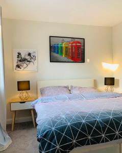 Alpha, Private Double Room, City Centre, Free Parking, Sittingbourne, Kent في سيتينغبورن: غرفة نوم بسرير وصورة على الحائط