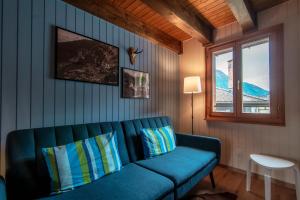 een woonkamer met een blauwe bank en een raam bij Casa Bella Oschesina by Quokka 360 - in the village of Osco in Osco