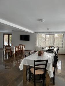 a dining room with tables and chairs and a flat screen tv at Silver Mountain Villa Colibita in Colibiţa