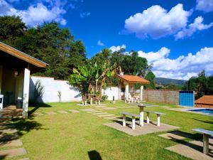 a yard with benches and a swimming pool at Escondidinho da Serra in Serra Negra
