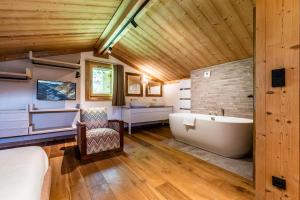 een badkamer met een bad en een wastafel bij Apartment Tahoe Les Gets - by EMERALD STAY in Les Gets