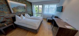 una camera da letto con un letto, un tavolo e una finestra di Hotel Eremitage ad Arlesheim