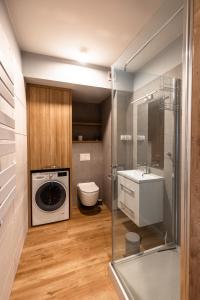 a bathroom with a washing machine and a sink at Apartment Natura Vision in Opole