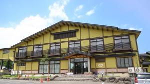 大崎市にあるTabinoyado Yakurai Rinsenkanの黄色の建物