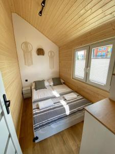 sypialnia z łóżkiem w drewnianym pokoju w obiekcie Domki Przy Brzegu Chłapowo we Władysławowie