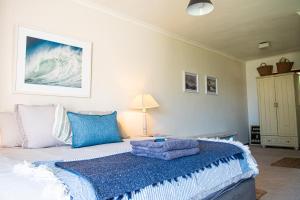 a bedroom with a bed with a blue and white blanket at Langebaan-On-Sea in Langebaan