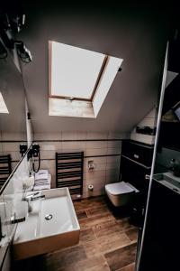 La salle de bains est pourvue d'un lavabo, de toilettes et d'une fenêtre. dans l'établissement Jantarvia Car Museum , Pasja i Wypoczynek Noclegi z Klimatem, à Jantar