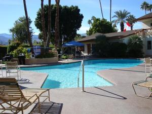 uma grande piscina com cadeiras e um edifício em The Inn at Deep Canyon em Palm Desert