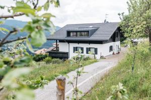 a white house with a black roof at Lisis Loggia in Nova Ponente