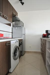a kitchen with a washer and a washing machine at T2 moderne avec terrasse a 100m de la plage et parking sécurisé 4 PERS MAXI in Saint Pierre La Mer