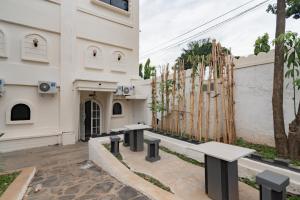 a building with benches in front of a building at Urbanview Hotel Kangen Bungalow Purwakarta by RedDoorz in Maracang-tua