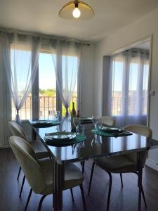 a dining room table with chairs and a large window at Le Thourottois*Centre ville*Wifi*Spacieux*Confort* Saint-Gobain in Thourotte