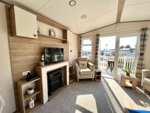 uma sala de estar com lareira e televisão em Forget Me Not Caravan - Littlesea Haven Holiday Park, Weymouth em Wyke Regis