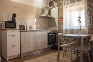 a kitchen with a table and a microwave at Casa da Eira de Santo Amaro in Ponte da Barca