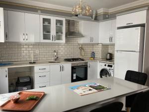 una cucina con armadi bianchi e piano di lavoro di Senturkler Suite a Trabzon